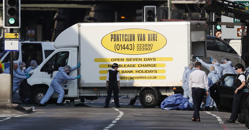 Forensic officers move the van at Finsbury Park in north London, where a vehicle struck pedestrians in north London Monday, June 19, 2017. The vehicle struck pedestrians near a mosque in north London  ...