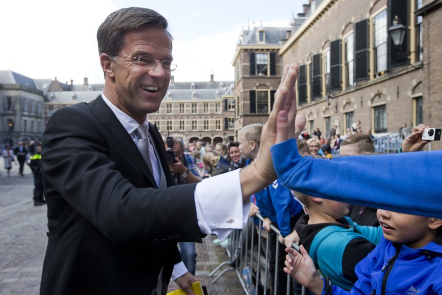 In this Sept. 19, 2017 file photo Dutch Prime Minister Mark Rutte high-fives with children as arrives in The Hague, Netherlands for a ceremony marking the opening of the parliamentary year. If Angela  ...