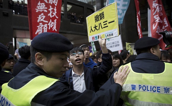 epa05871071 Activist Joshua Wong (C) shouts slogans with other pro-democracy supporters during a rally near the Convention Center in Hong Kong, China, 26 March 2017. Hong Kong is choosing its next lea ...