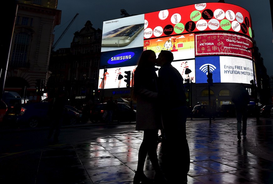 A couple embrace in Piccadilly Circus in London, Britain, November 19, 2015. REUTERS/Toby Melville
