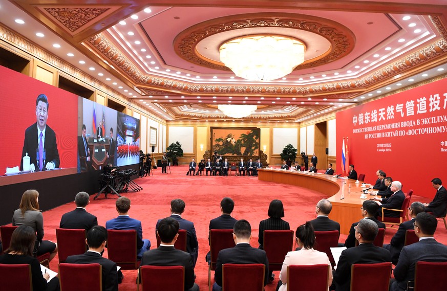 epa08039042 A general view shows China&#039;s President Xi Jinping speaking with Russian President Vladimir Putin via a video link, from the Great Hall of the People in Beijing, China, 02 December 201 ...