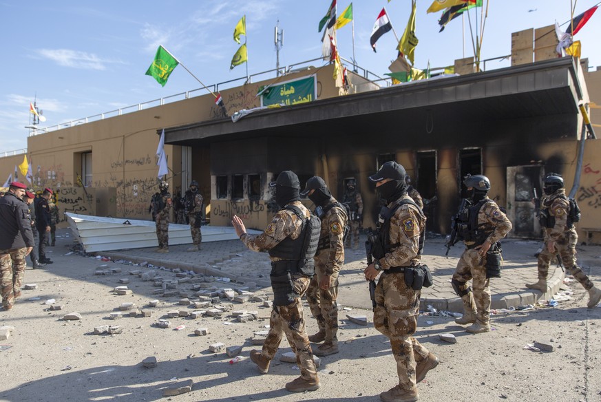 Iraqi army soldiers are deployed in front of the U.S. embassy, in Baghdad, Iraq, Wednesday, Jan. 1, 2020. Iran-backed militiamen have withdrawn from the U.S. Embassy compound in Baghdad after two days ...