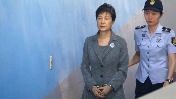 epa06161274 South Korean Former President Park Geun-hye (C) is escorted to a courtroom in Seoul, South Korea, 25 August 2017, to stand trial on alleged bribery, abuse of power and leaks of government  ...