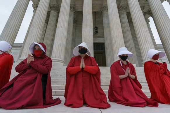 Activists opposed to the confirmation of President Donald Trump&#039;s Supreme Court nominee, Judge Amy Coney Barrett, are dressed as characters from &quot;The Handmaid&#039;s Tale,&quot; at the Supre ...