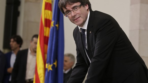 Catalan regional President Carles Puigdemont signs an independence declaration document after a parliamentary session in Barcelona, Spain, Tuesday, Oct. 10, 2017. Puigdemont says he has a mandate to d ...