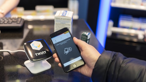 ARCHIVBILD ZU RAZZIA BEI TWINT --- [Staged Picture] A person uses the Twint cashless payment system via app on a smartphone at a Twint beacon terminal in an Amavita pharmacy in Berne, Switzerland, on  ...