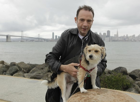 FILE - In this May 16, 2011 file photo Timothy Ray Brown poses with his dog, Jack, on Treasure Island in San Francisco. Brown, who made history as