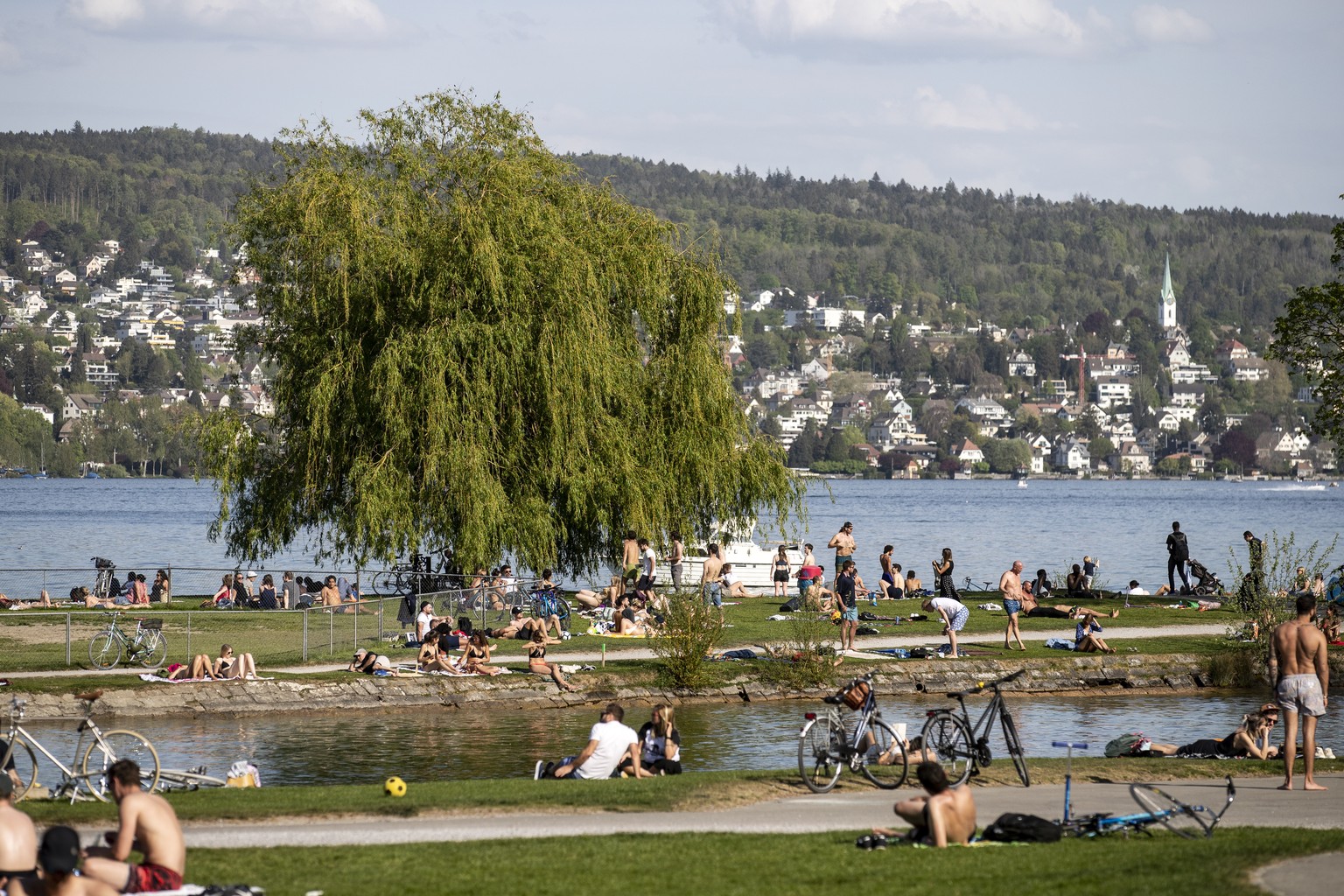 Menschen geniessen das schoene Wetter auf der Landiwiese am Samstag, 18. April 2020, in Zuerich. (KEYSTONE/Alexandra Wey).