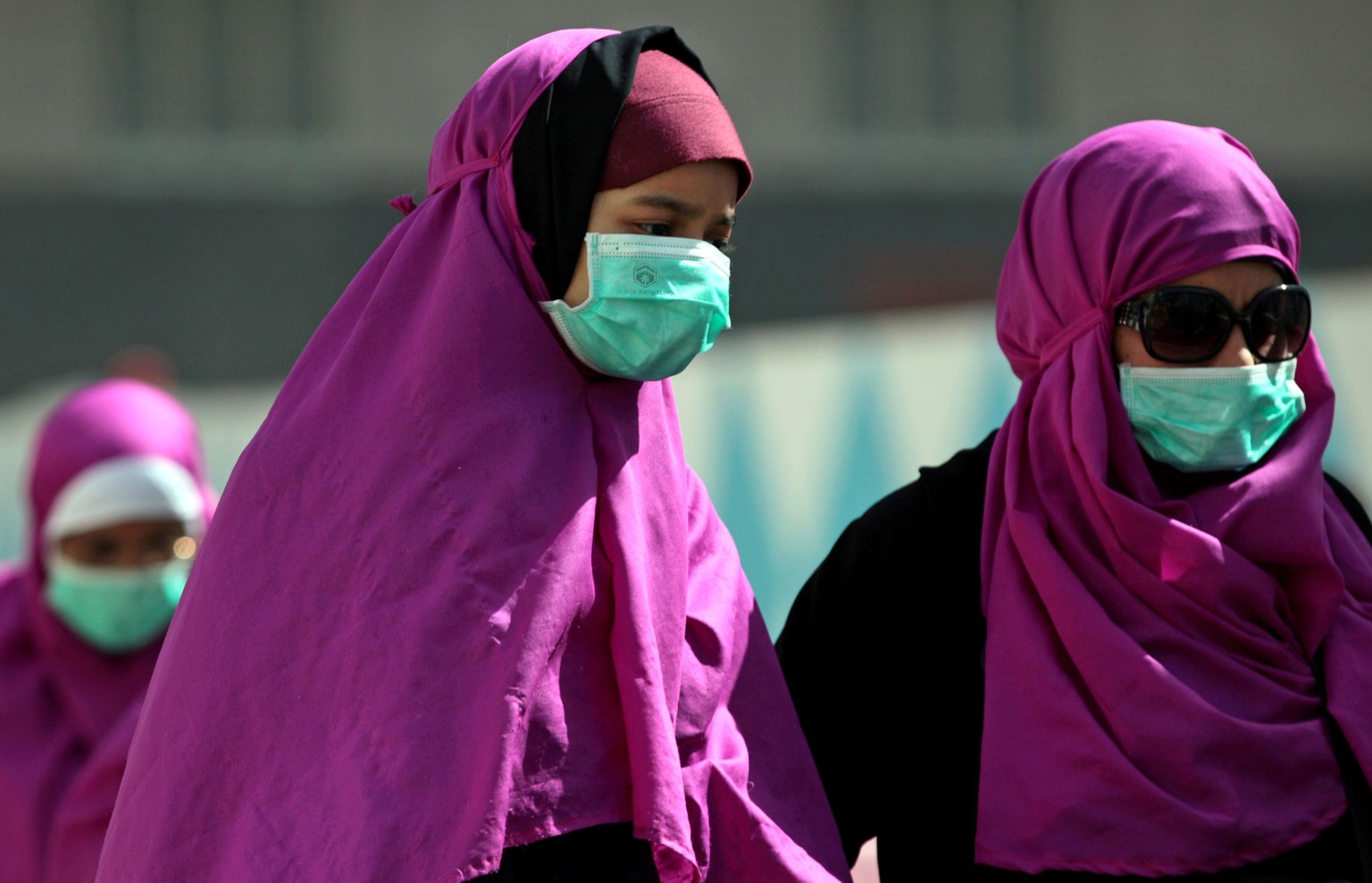 FILE -- In this Tuesday May, 13, 2014 file photo, Muslim pilgrims wear surgical masks to prevent infection from respiratory virus known as the Middle East respiratory syndrome (MERS) in the holy city  ...
