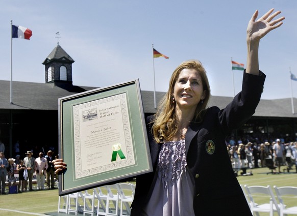 International Tennis Hall of Fame inductee Monica Seles waves to the crowd as she holds her plaque during ceremonies in Newport, R.I. Saturday, July 11, 2009. (AP Photo/Elise Amendola)