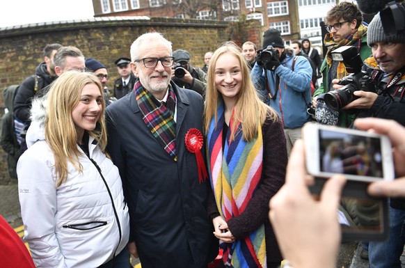 epa08064723 Opposition Labour Party Leader Jeremy Corbyn (C) poses for a photograph as he leaves after voting at a polling station during the general elections in London, Britain, 12 December 2019. Br ...