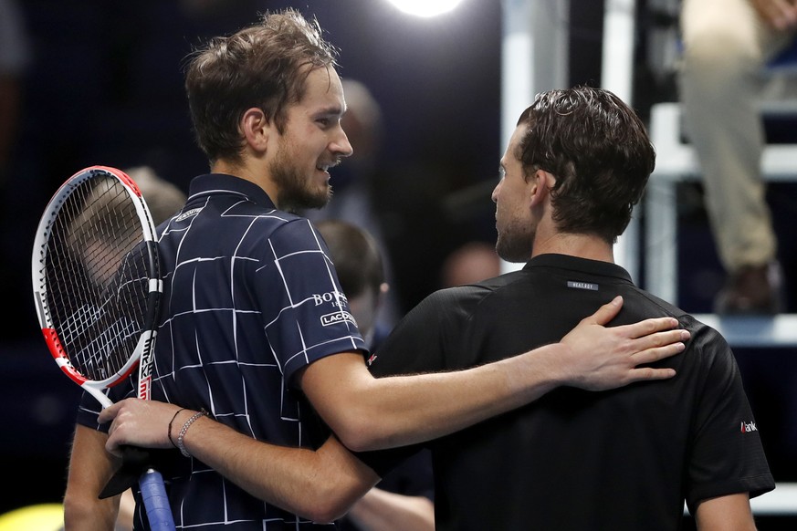Daniil Medvedev of Russia, left, puts his arm around Dominic Thiem of Austria after he wins their singles final tennis match at the ATP World Finals tennis tournament at the O2 arena in London, Sunday ...
