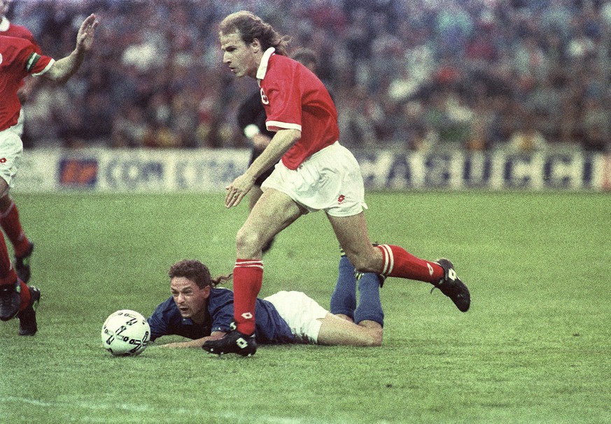 Marc Hottiger zieht im WM-Qualifikationsspiel Schweiz-Italien am 1. Mai 1993 im Wankdorf-Stadion in Bern am gestuerzten italienischen Spieler Roberto Baggio vorbei. Hottiger erzielt fuer die Schweiz i ...