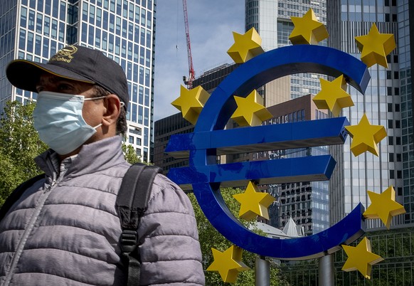 A man walks by the Euro sculpture in front of the old the European Central Bank in Frankfurt, Germany, Tuesday, May 5, 2020. Germany&#039;s Constitutional Court has ruled that the country&#039;s centr ...