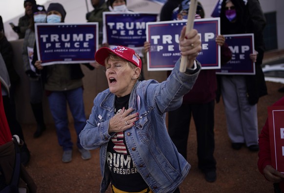 A supporter of President Donald Trump holds her hand over her heart during a protest of the election outside of the Clark County Election Department in North Las Vegas on Nov. 8, 2020. (AP Photo/John  ...