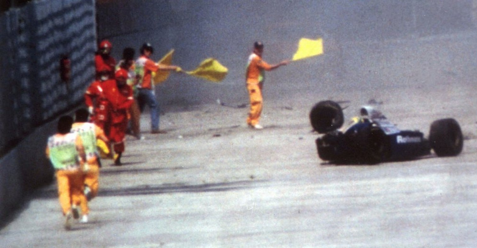 Race officials run toward Brazil&#039;s Aytron Senna after he crashed with his Williams-Renault during the San Marino F-1 Grand Prix in Imola Sunday May 1, 1994. Senna died at a Bologna hospital later ...