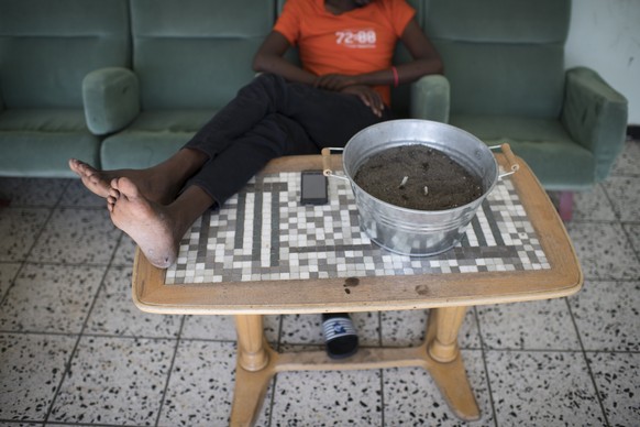 Ein Asylsuchender macht Pause im Raucherraum, aufgenommen an einem Rundgang im Asylzentrum Sonnenberg, am Freitag, 8. Juli 2017, in Vilters. (Keystone/Gian Ehrenzeller)