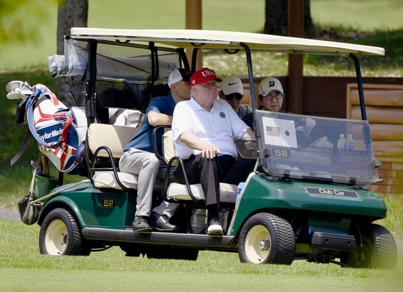 U.S. President Donald Trump, center, rides in a golf cart with Japanese Prime Minister Shinzo Abe, right, as they play a round of golf at Mobara Country Club in Mobara, south of Tokyo, Sunday, May 26, ...