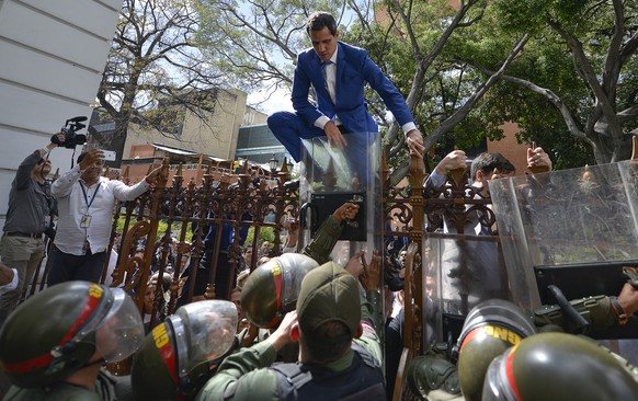 National Assembly President Juan Guaido, Venezuela&#039;s opposition leader, climbs the fence in a failed attempt to enter the compound of the Assembly, as he and other opposition lawmakers are blocke ...