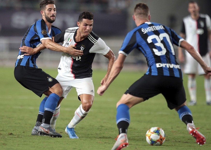 Roberto Gagliardini of Inter Milan, left, and teammate Milan Å kriniar, right, try to stop Cristiano Ronaldo of Juventus, center, in a friendly match of the International Champions Cup in Nanjing in e ...