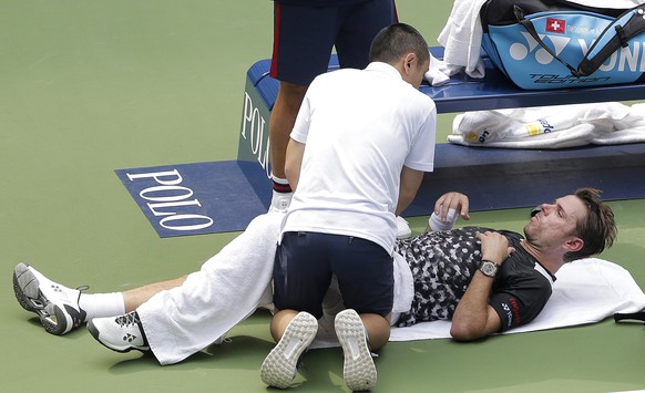 Stan Wawrinka, of Switzerland, gets medical treatment during the first round of the U.S. Open tennis tournament against Grigor Dimitrov, of Bulgaria, Monday, Aug. 27, 2018, in New York. (AP Photo/Seth ...