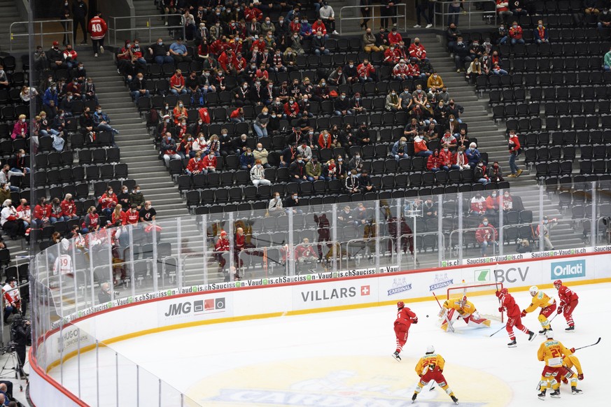 Les spectateurs portant un masque de protection facial observent les joueurs lors du match du championnat suisse de hockey sur glace de National League entre le Lausanne HC et le SCL Langnau Tigers ce ...