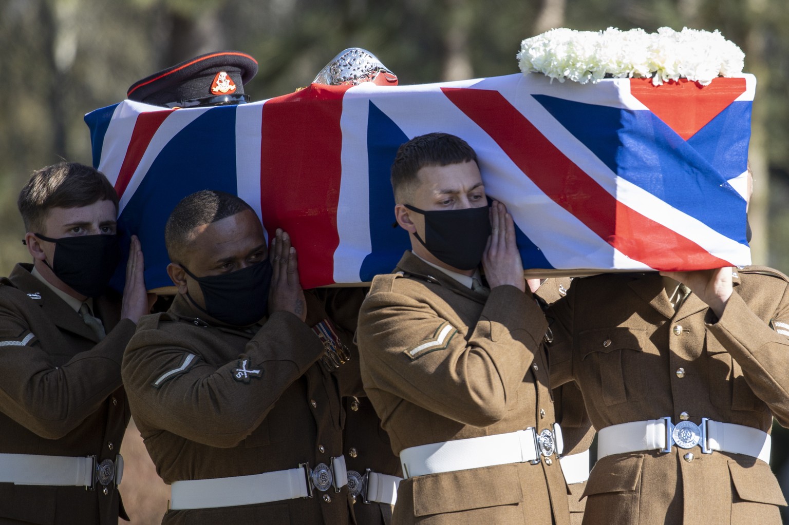epa09040336 A handout picture provided by the British Ministry of Defence shows the coffin of Captain Tom Moore carried by members of the Armed Forces at Bedford Crematorium in Bedford, Britain 27 Feb ...