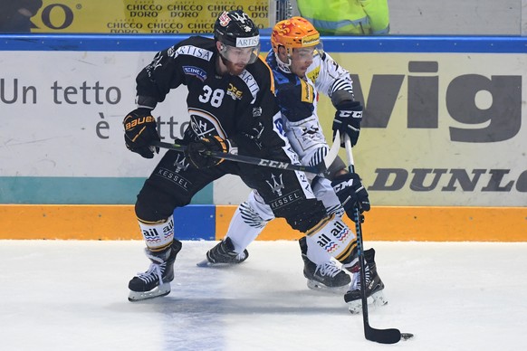 Lugano&#039;s player Raffaele Sannitz, left, fights for the puck with Ambri&#039;s player Michael Fora, right, during the preliminary round game of National League Swiss Championship 2017/18 between S ...