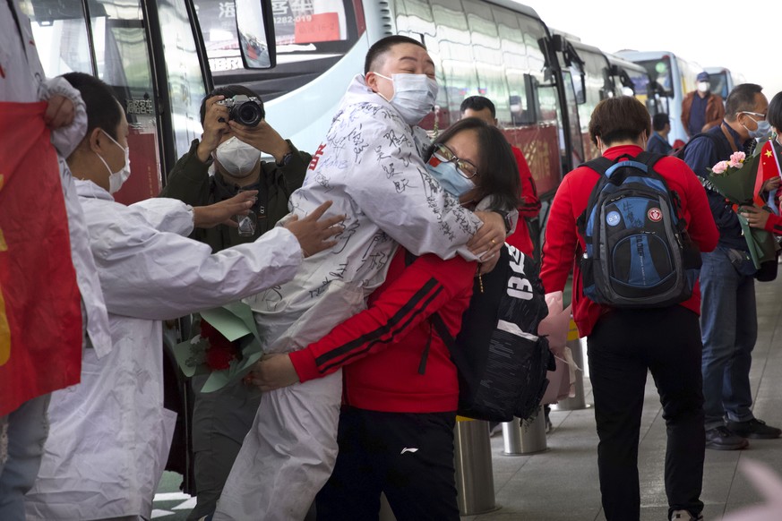A medical worker from China&#039;s Jilin Province, in red, embraces a colleague from Wuhan as she prepares to return home at Wuhan Tianhe International Airport in Wuhan in central China&#039;s Hubei P ...