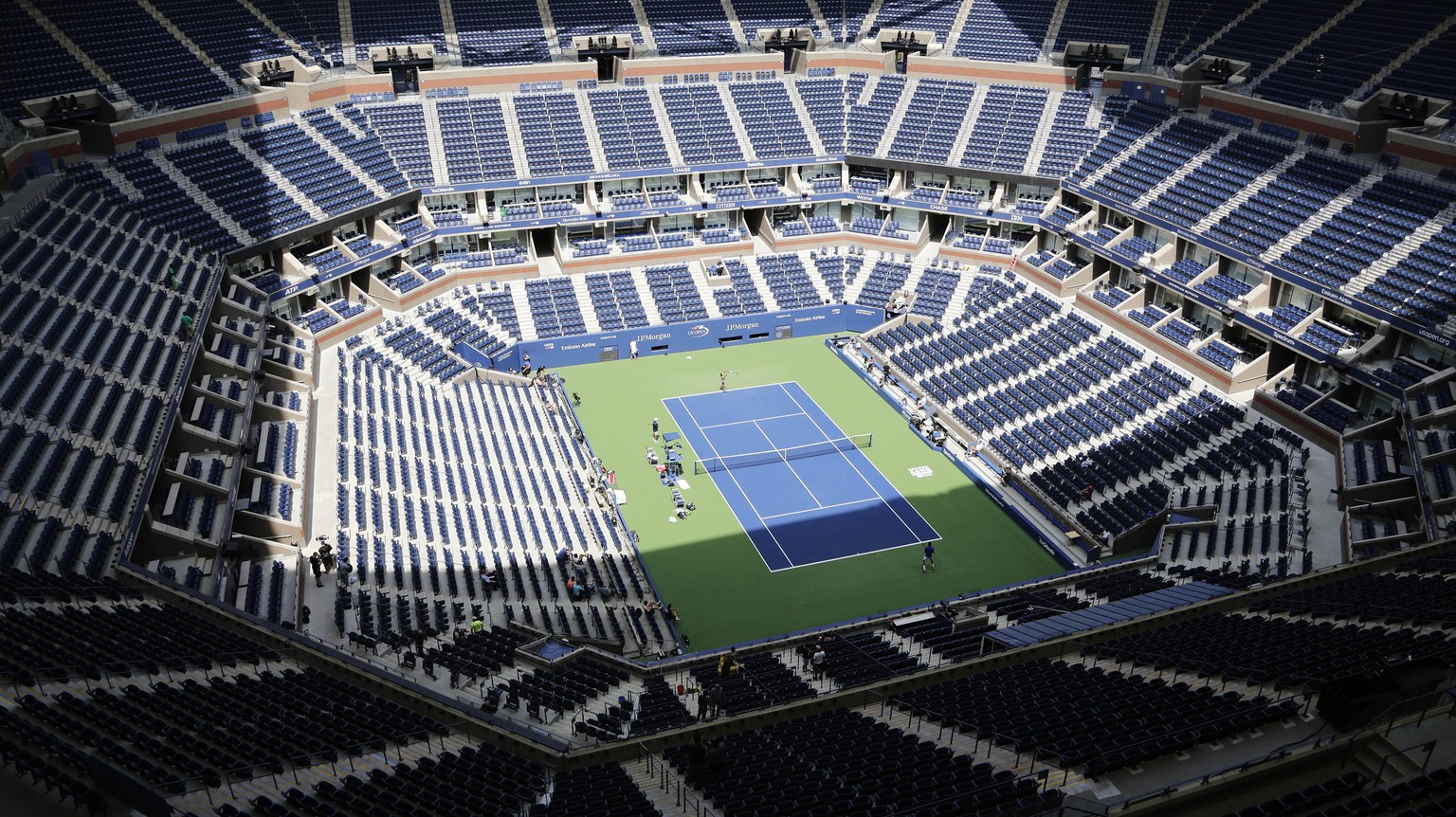 FILE - In this Aug. 27, 2017, file photo, players practice for the U.S. Open tennis tournament at Arthur Ashe Stadium in New York. As coronavirus cases spike in other parts of the country a month befo ...