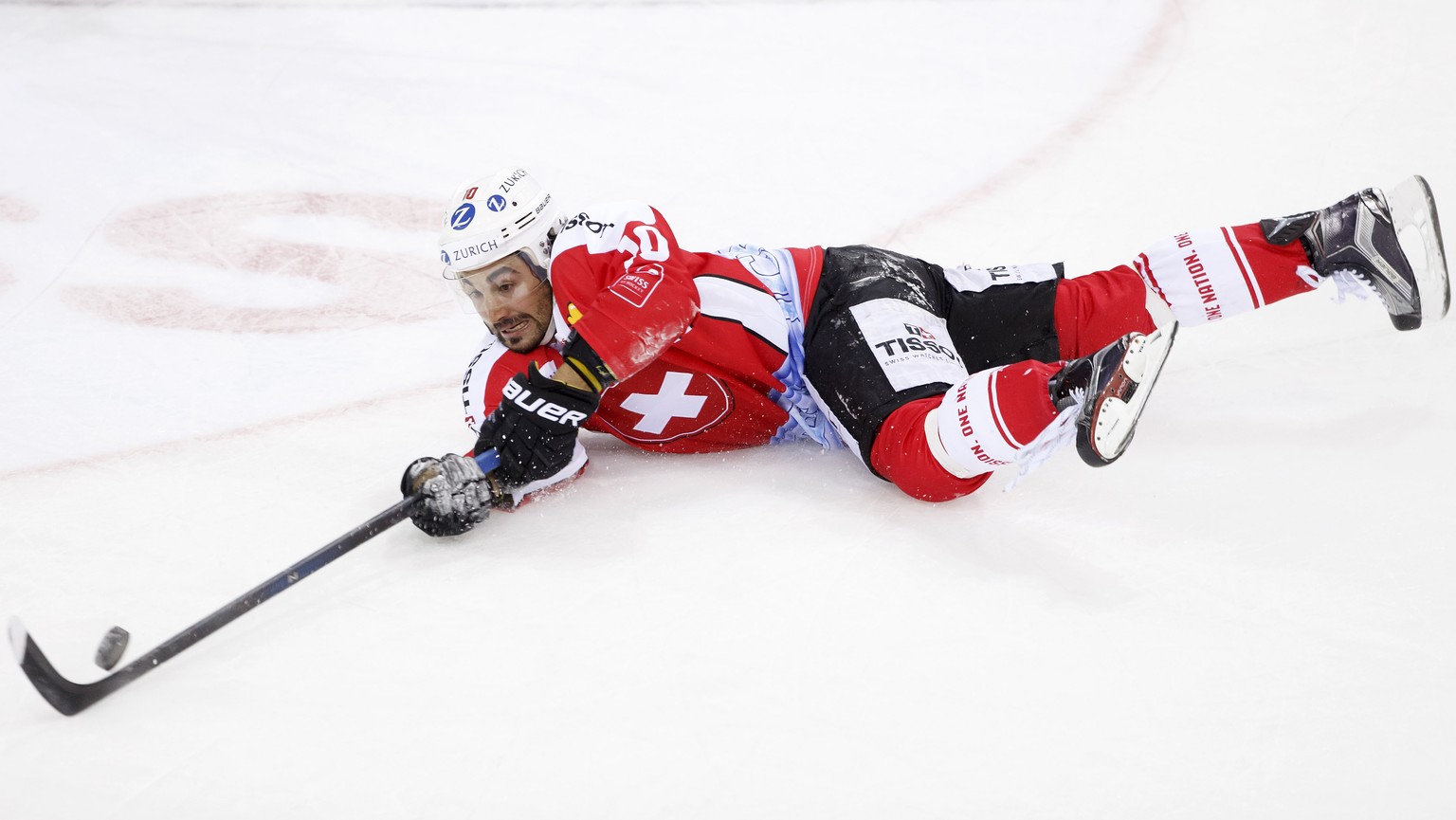 Switzerland&#039;s Andres Ambuehl tries to catch the puck, during friendly ice hockey game between Switzerland and Latvia, at the ice stadium Les Vernets, in Geneva, Switzerland, Friday, April 29, 201 ...
