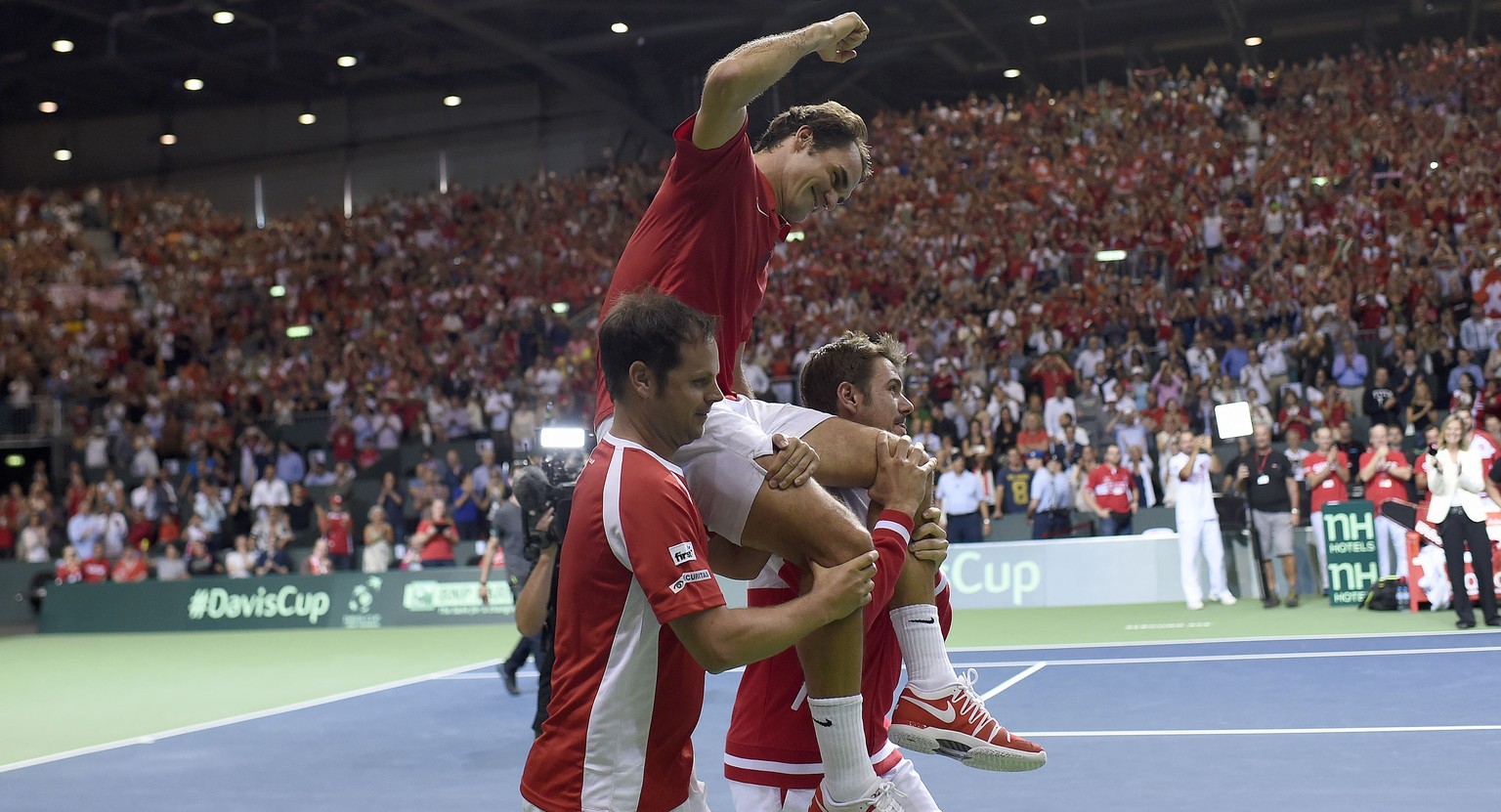 Roger Federer wird von Severin Lüthi und Stan Wawrinka durch die Arena getragen.