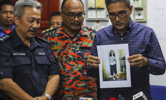 epa07757995 Negeri Sembilan Police Chief Mohamad Mat Yusop (R) holds the pictures of 15-year-old Nora Quoirin from London who is reported missing in Malaysia, during a press conference in Seremban, Ne ...