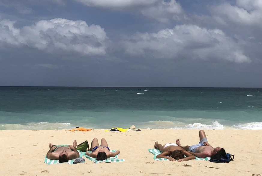 In this March 12, 2018, photo, foreign tourists sunbathe at a beach on Boracay island, central Aklan province, Philippines. Philippine officials say the president has approved the closure of Boracay i ...