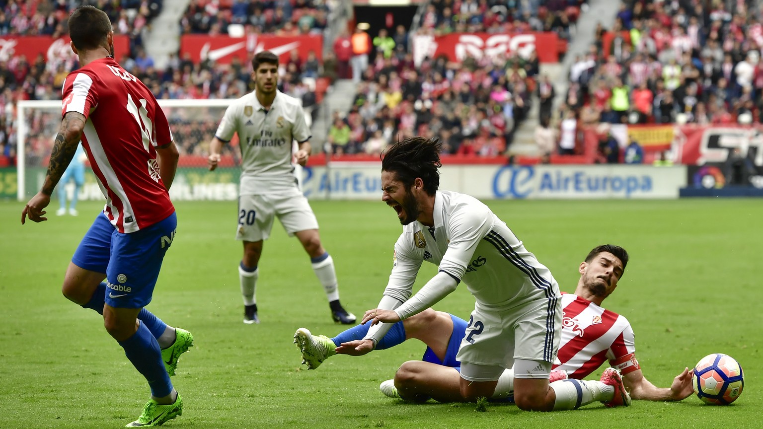 Real Madrid&#039;s Isco, is tackled by Sporting de Gijon&#039;s Sergio Alvarez during the Spanish La Liga soccer match between Real Madrid and Sporting de Gijon, at El Molinon stadium in Gijon, northe ...