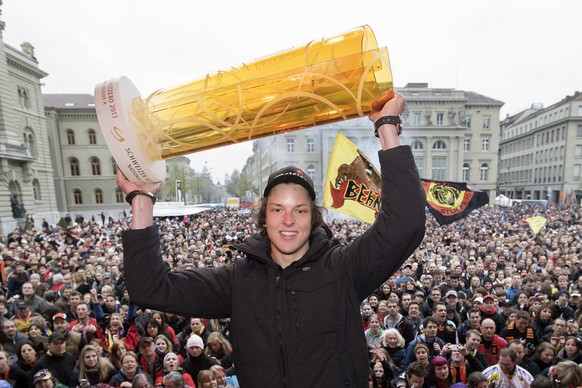 Kevin Loetscher haelt den Meisterpokal hoch bei der Meisterfeier des SCB am Samstag, 20. April 2013 auf dem Bundesplatz in Bern. (KEYSTONE/Peter Klaunzer)