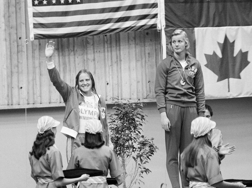 FILE - In this July 19, 1976, file photo, East German swimmer Kornelia Ender, right, who was awarded the Olympic gold medal for the 200 meter freestyle event, stands on the podium, as her main opponen ...