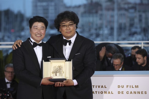 Actor Kang-Ho Song, left and director Bong Joon-ho pose with the Palme d&#039;Or award for the film &#039;Parasite&#039; during a photo call following the awards ceremony at the 72nd international fil ...