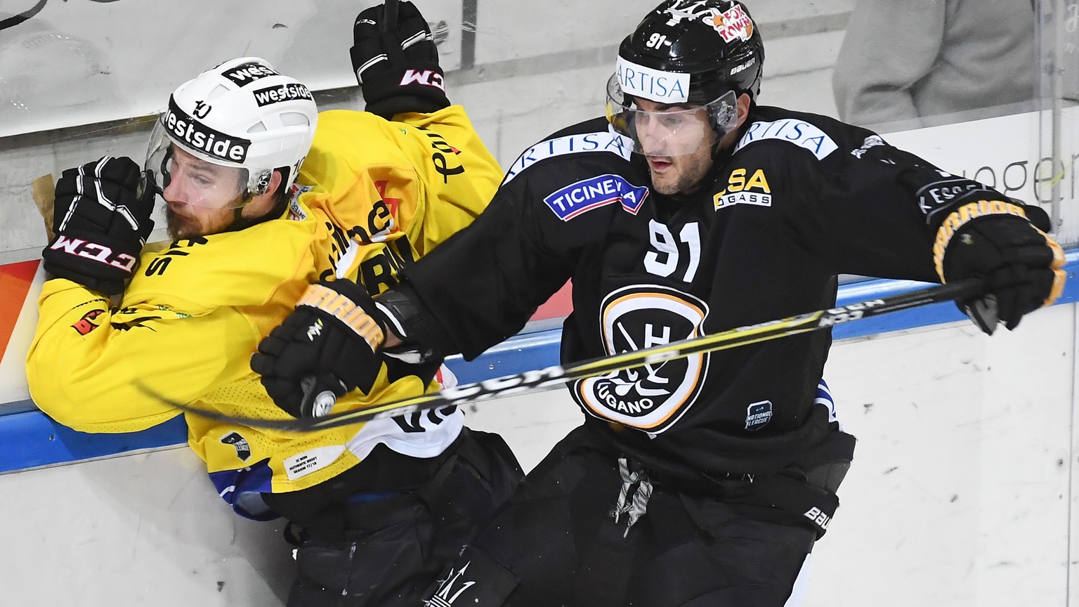 Bern&#039;s player Tristan Scherwey, left, fights for the puck with Lugano’s player Julian Walker, right, during the preliminary round game of National League Swiss Championship 2017/18 between HC Lug ...