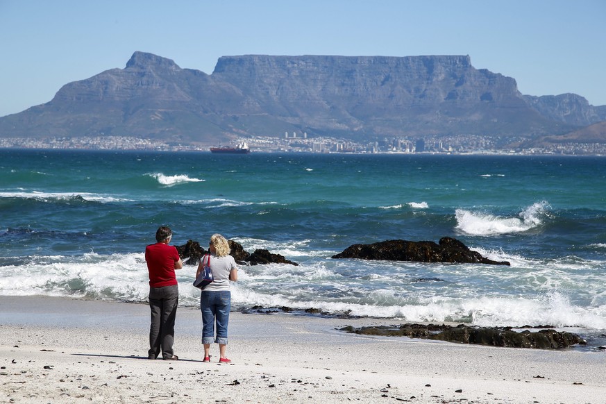 epa04120029 A couple looks across False Bay towards the iconic Table Mountain and the city of Cape Town, South Africa 11 March 2014. Cape Town is the World Design Capital of 2014. Cape Town being desi ...