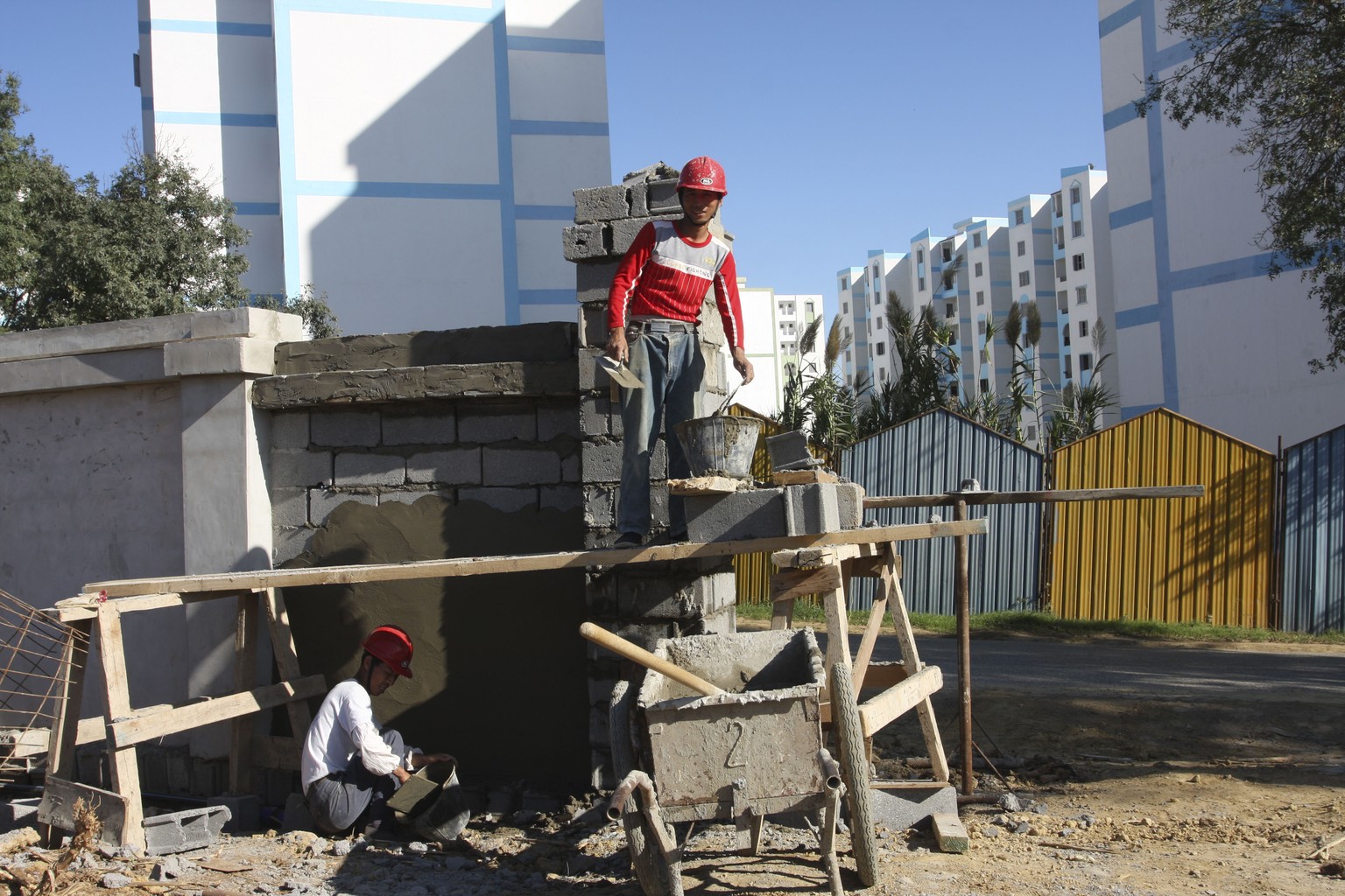 FILE - In this Oct. 11, 2009 file photo, Chinese workers build a wall at a housing project funded by the Algerian government and built by a state-owned Chinese firm near Algiers, Algeria. U.S. direct  ...