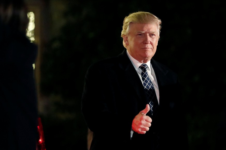U.S. President-elect Donald Trump gives a thumbs up to the media as he arrives at a costume party at the home of hedge fund billionaire and campaign donor Robert Mercer in Head of the Harbor, New York ...