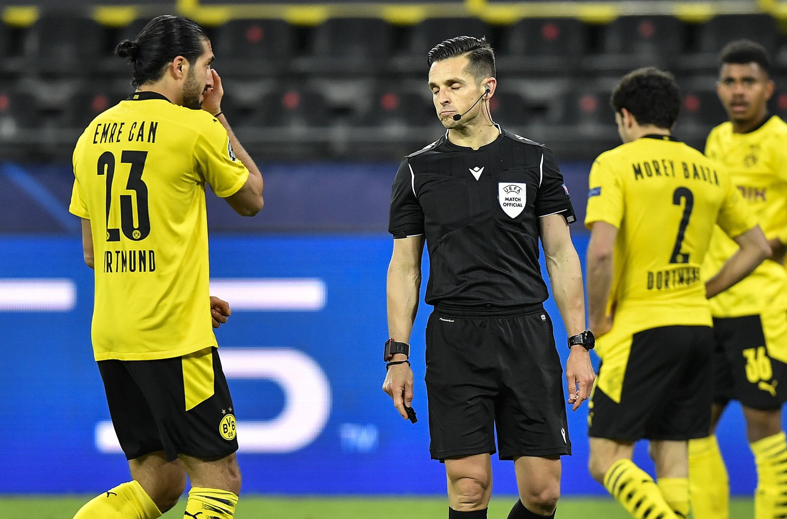 Dortmund&#039;s Emre Can, left, talks to referee Carlos del Cerro Grande, after he decided penalty for Can using his hand during the Champions League quarterfinal 2nd leg soccer match between Borussia ...