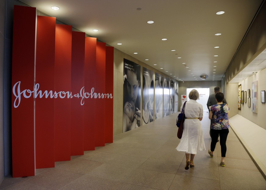 FILE - In this July 30, 2013, file photo, people walk along a corridor at the headquarters of Johnson &amp; Johnson in New Brunswick, N.J. Johnson &amp; Johnson&#039;s long-awaited vaccine appears to  ...