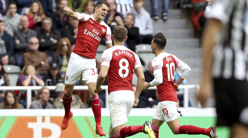 Arsenal&#039;s Granit Xhaka, left, celebrates scoring his side&#039;s first goal of the game with teammates, during the English Premier League soccer match between Newcastle United and Arsenal at St J ...