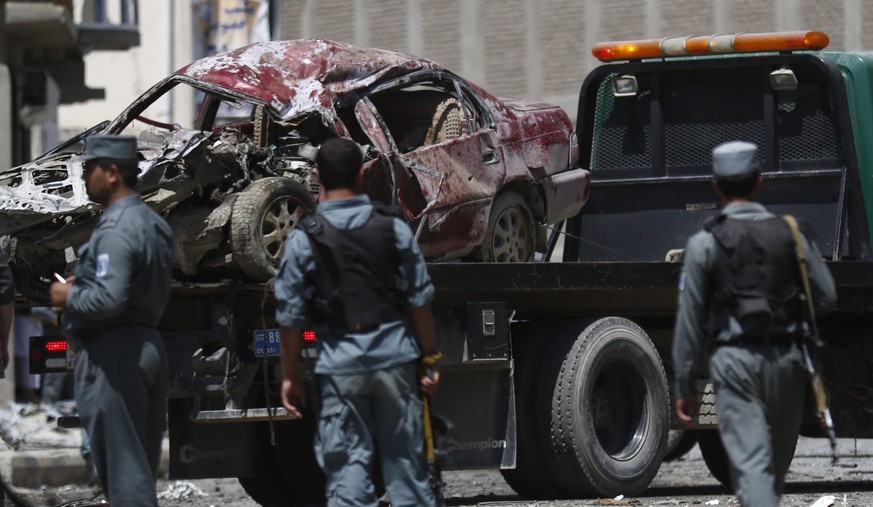 Anschlag in Kabul: Sicherheitskräfte transportieren ein schwer beschädigtes Auto ab.