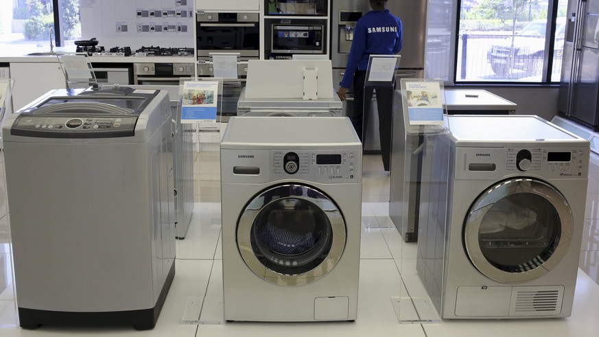 Samsung washing machines are seen as an employee inspects refrigerators at a Samsung display store in Johannesburg, in this October 3, 2013 file photo. REUTERS/Siphiwe Sibeko/Files