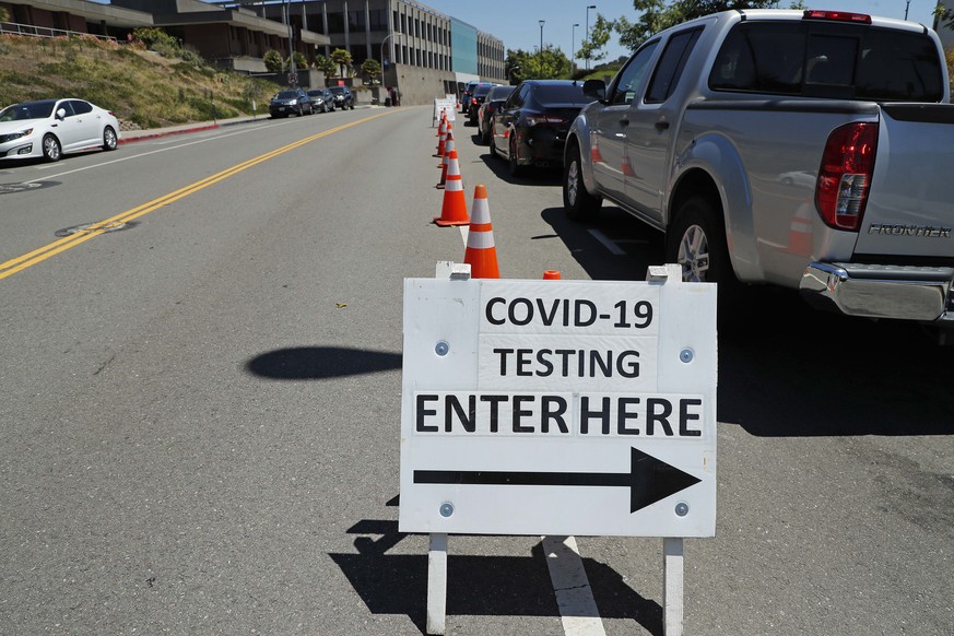 epa08524045 Vehicles line up at a drive-through COVID-19 makeshift testing facility operated by the Hayward Fire Department on the California State University East Bay campus in Hayward, California, U ...