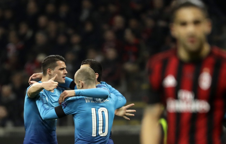 Arsenal&#039;s Henrikh Mkhitaryan celebrates with teammates after scoring his side&#039;s opening goal during the Europa League round of 16 first-leg soccer match between AC Milan and Arsenal, at the  ...