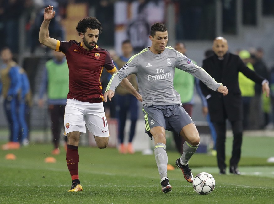 Roma&#039;s Mohamed Salah, left, challenges Real Madrid&#039;s Cristiano Ronaldo during a Champions League, round of 16, first-leg soccer match between Roma and Real Madrid, at the Rome Olympic stadiu ...